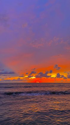 an orange and blue sunset over the ocean