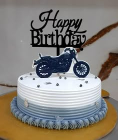 a birthday cake with a motorcycle on top and the words happy birthday written in black