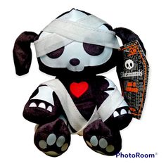 a black and white stuffed animal with bandages on it's head, sitting in front of a white background