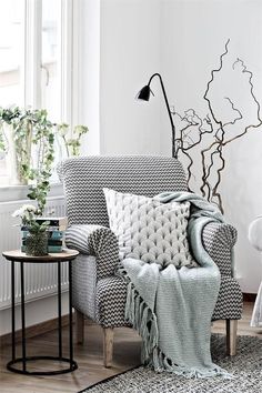 a living room filled with furniture next to a window and potted plant on top of a table