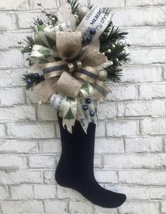 a christmas stocking hanging on a brick wall with ribbon and bells attached to it