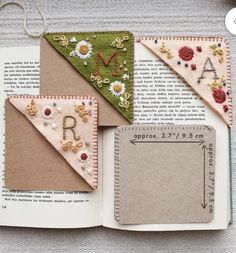 an open book that has some fabric on top of it with letters and flowers in the pages