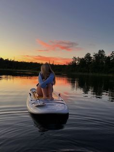 a woman sitting on top of a paddle boat in the middle of a body of water