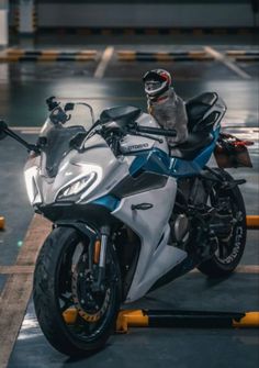 a white and blue motorcycle parked in a parking garage