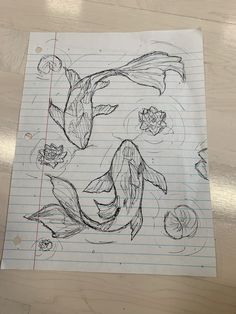 a drawing of a koi fish and lily pads on lined paper with pencils