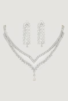 Elevate your style with the 2-Layer Faux Diamond Necklace Set, featuring a sophisticated design crafted from mixed metals with a gleaming white finish. The two-layer necklace showcases dazzling faux diamonds, exuding luxury and elegance, while the matching earrings complete the ensemble. Perfect for cocktails, Sangeet nights, or evening parties, this set adds a touch of glamour to any occasion, ensuring you stand out with effortless grace. Dimensions (Inches) : Necklace - 5.5 x 4, Earrings - 2 x 0.5 Composition : Mixed Metal and Faux Diamonds Care: Keep away from water and perfume Delivery : 6-8 weeks as the product is hand crafted. For more information and sizes please contact fabiliciousfashion@gmail.com or visit our Copenhagen studio. About the Designer : If you're a bride-to-be or simp 4 Earrings, Indian Theme, Indian Wedding Wear, Diamond Necklace Set, Layer Necklace, Sophisticated Design, Mixed Metals, Exquisite Jewelry, Wedding Wear