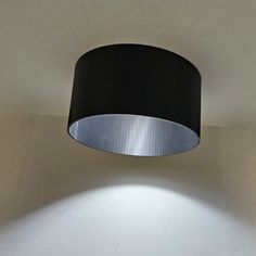 a black lamp shade hanging from the ceiling