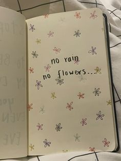 an open notebook with writing on it and flowers in the pages that say no rain, no flowers