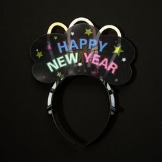 a mickey ears headband with the words happy new year written in neon on it