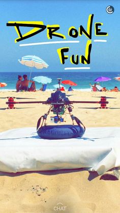 a helicopter sitting on top of a sandy beach next to the ocean with umbrellas