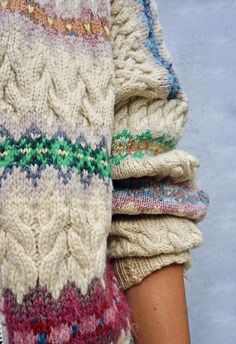 a close up of a person's arm wearing knitted sweaters