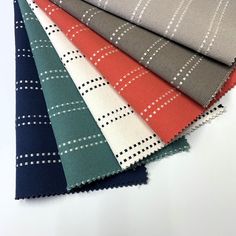 several different colors of fabric on top of each other, including red, grey, and blue