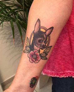 a woman's arm with a small chihuahua tattoo on it