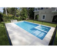 an empty swimming pool in the middle of a yard with fenced in areas around it