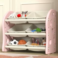 a pink toy shelf with lots of toys on it's sides and balls in the bins