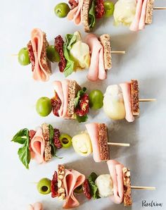 small appetizers are arranged on toothpicks with meat, cheese and vegetables