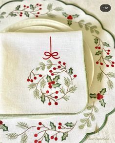 three placemats with holly and berries on them, one has a red ribbon