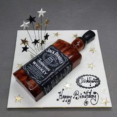 a birthday cake made to look like a bottle of whiskey and stars on the table