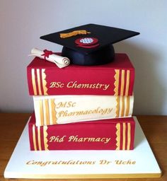 a cake made to look like books with a graduation cap on top and diploma in the middle