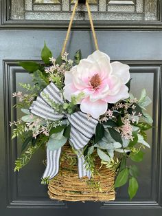 a basket with flowers hanging from the front door