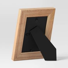 an empty wooden frame with a black ribbon hanging from it's side on a white background