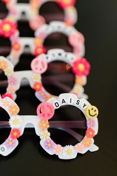 several pairs of sunglasses decorated with flowers and the words daisy written on them are sitting next to each other