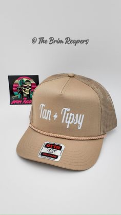 Elevate your beach look with the Tan + Tipsy Printed Trucker Hat, perfect for women who want to look stylish while sipping their favorite drinks by the beach.  * Eye-catching Design: The hat features a unique Tan + Tipsy print that will turn heads wherever you go.  * Comfortable Fit: The trucker hat design provides a comfortable fit for all head sizes, making it perfect for all-day wear.  * Summer Essential: This stylish accessory is a must-have for your summer wardrobe. Protect yourself from the sun while looking chic and trendy at the same time. The Tan + Tipsy Printed Trucker Hat is made of high-quality materials to ensure its durability and longevity. Whether you're lounging by the pool or taking a walk on the beach, this hat will keep you looking fabulous throughout your summer advent Beach Trucker Hats For Women, Drinks By The Beach, Trucker Hats For Women, Walk On The Beach, Taking A Walk, Hat Design, Summer Essential, By The Beach, Protect Yourself