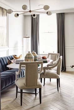 a dining room table with chairs and a couch in the corner next to it on a hard wood floor