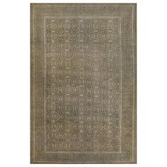 an antique rug with intricate design in grey and beige tones, on a white background