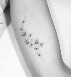 a woman's arm with stars and planets on the left side of her arm