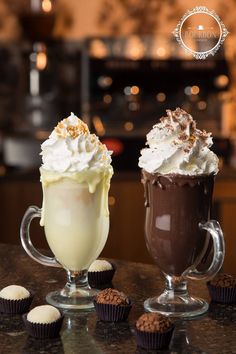 two glasses filled with different types of desserts on a table next to each other