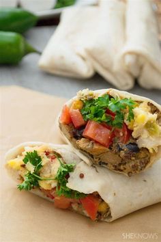 two burritos with vegetables and meat on them