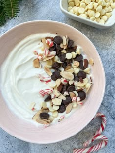 a bowl filled with white chocolate and candy canes next to two bowls of candies