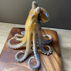 an octopus sculpture sitting on top of a wooden board