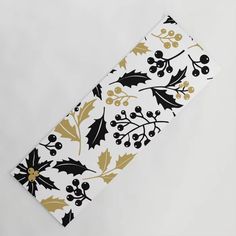 a white and gold christmas napkin with holly leaves