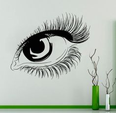 an eye with long lashes is shown on the wall