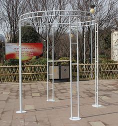 a white metal structure sitting on top of a sidewalk