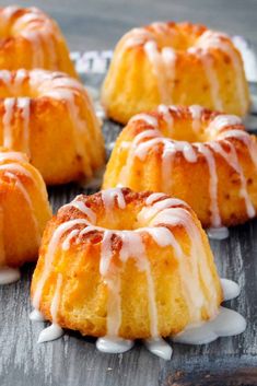 several bundt cakes with white icing on a wooden surface, ready to be eaten