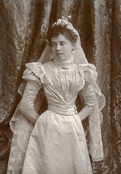 an old black and white photo of a woman in a wedding dress