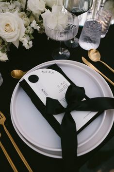 a black and white table setting with place settings, silverware, and napkins