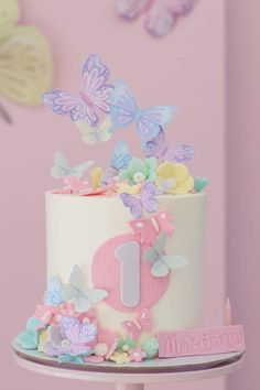 a white cake with pink and blue butterflies on it