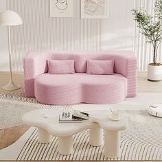 a living room with a pink couch and coffee table on the floor in front of it