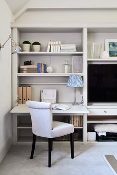 a white chair sitting in front of a desk with a tv on top of it