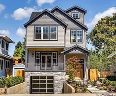 a two story house with a garage in the front yard