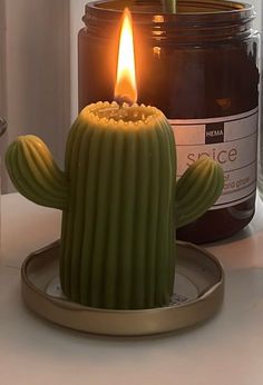 a candle that is sitting on a plate next to a jar with some kind of substance in it