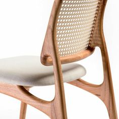 a wooden chair with a white seat and back cushion on top of it's legs