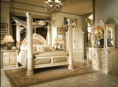 a large white bed sitting inside of a bedroom next to a chandelier and dresser