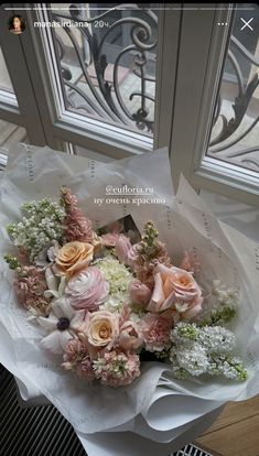 a bouquet of flowers sitting in front of a window