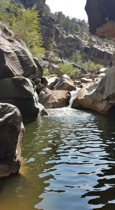 there is a small stream in the middle of some rocks