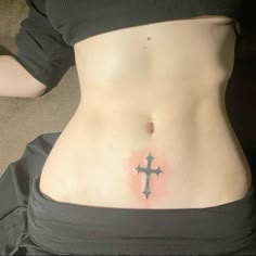 a woman with a cross tattoo on her stomach